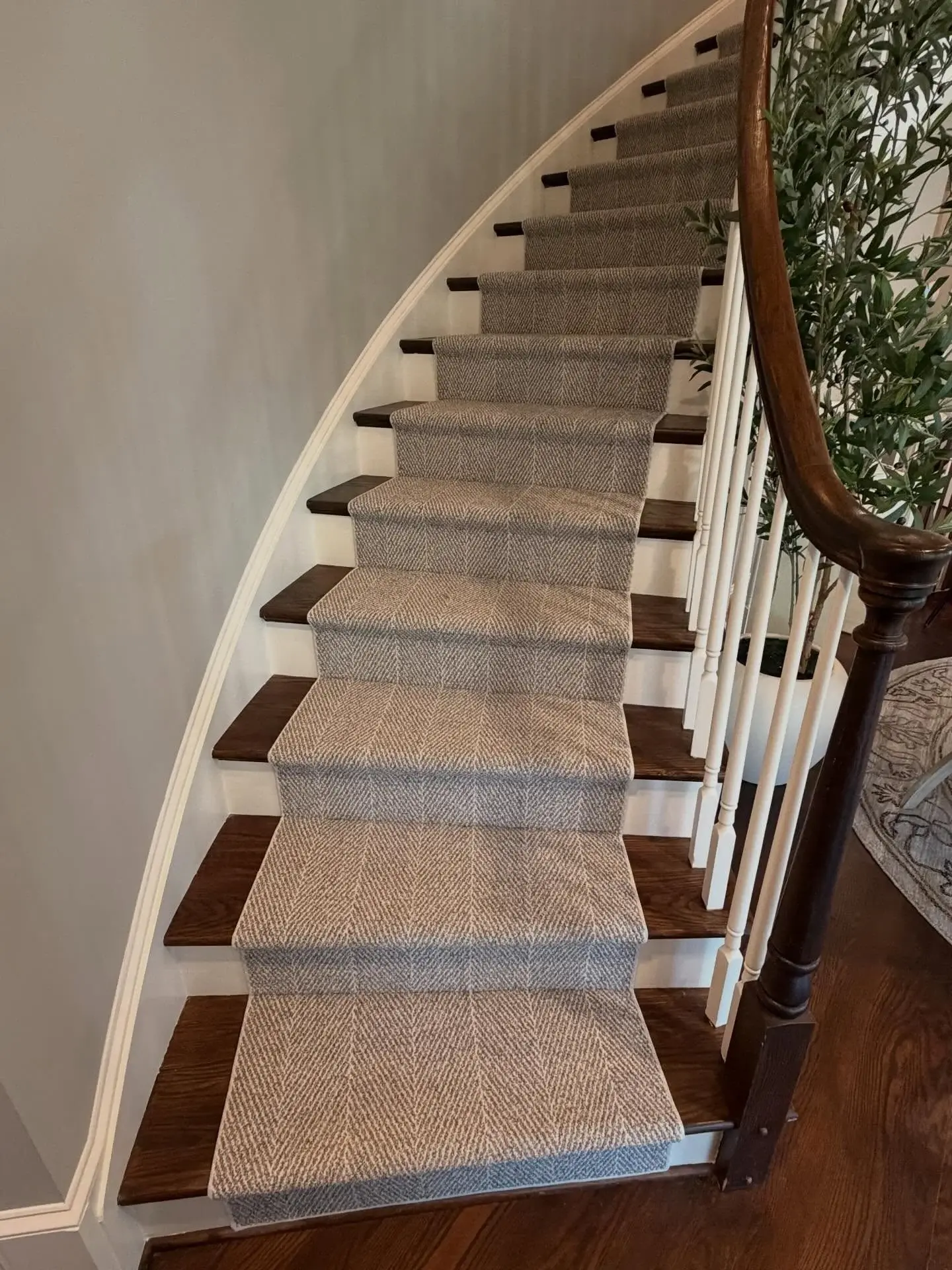 Neutral bound runner centered on wood stairs with white balusters