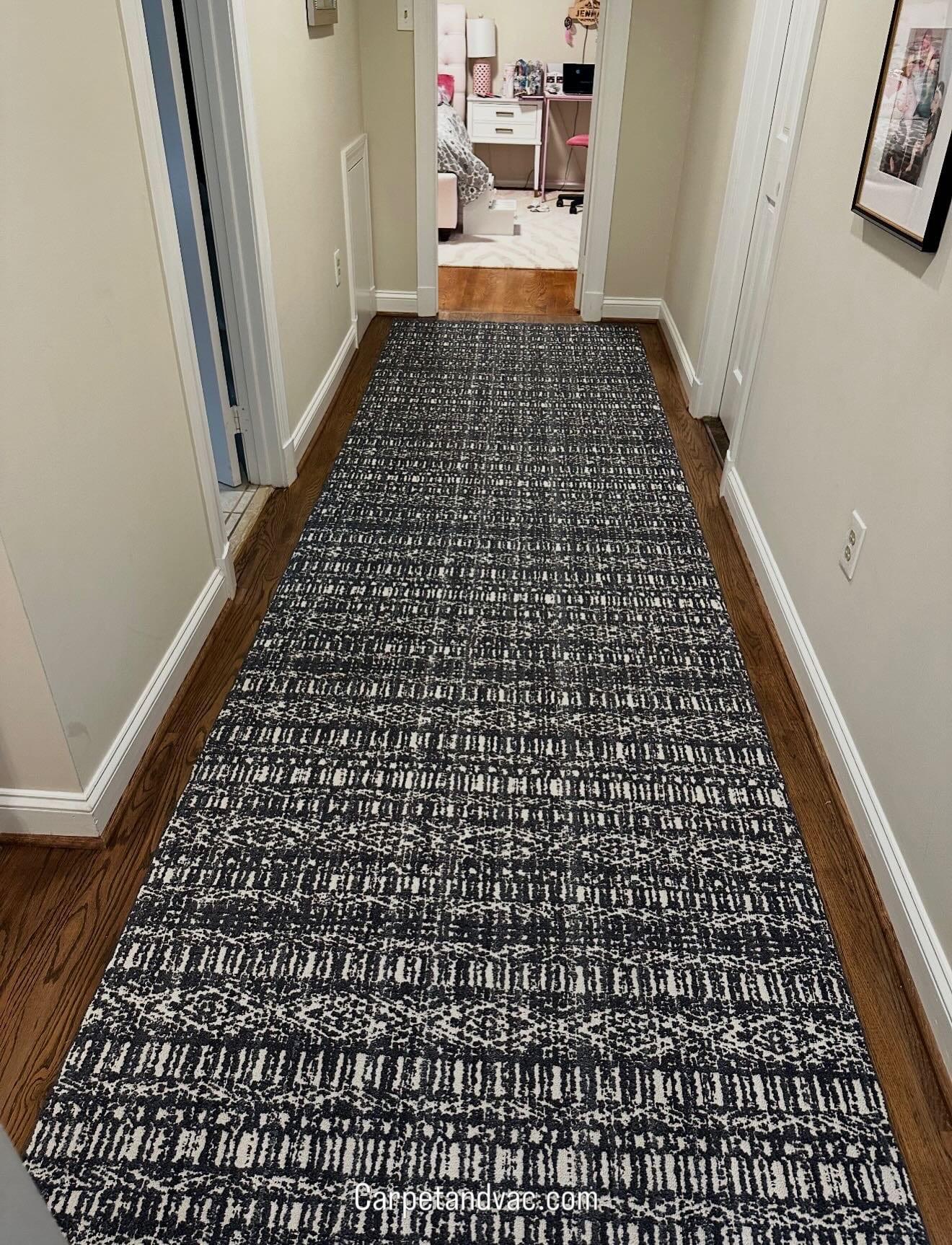Long hallway finished in the same dark patterned carpet