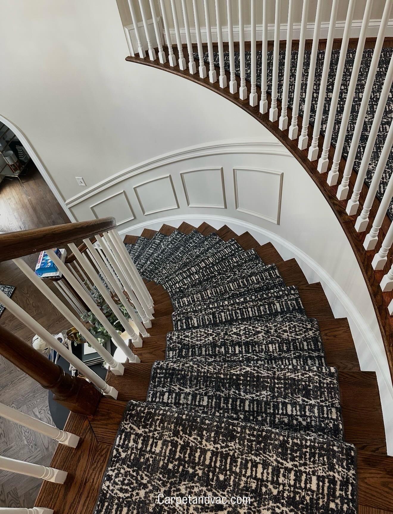 Patterned runner following a curved staircase with white balusters