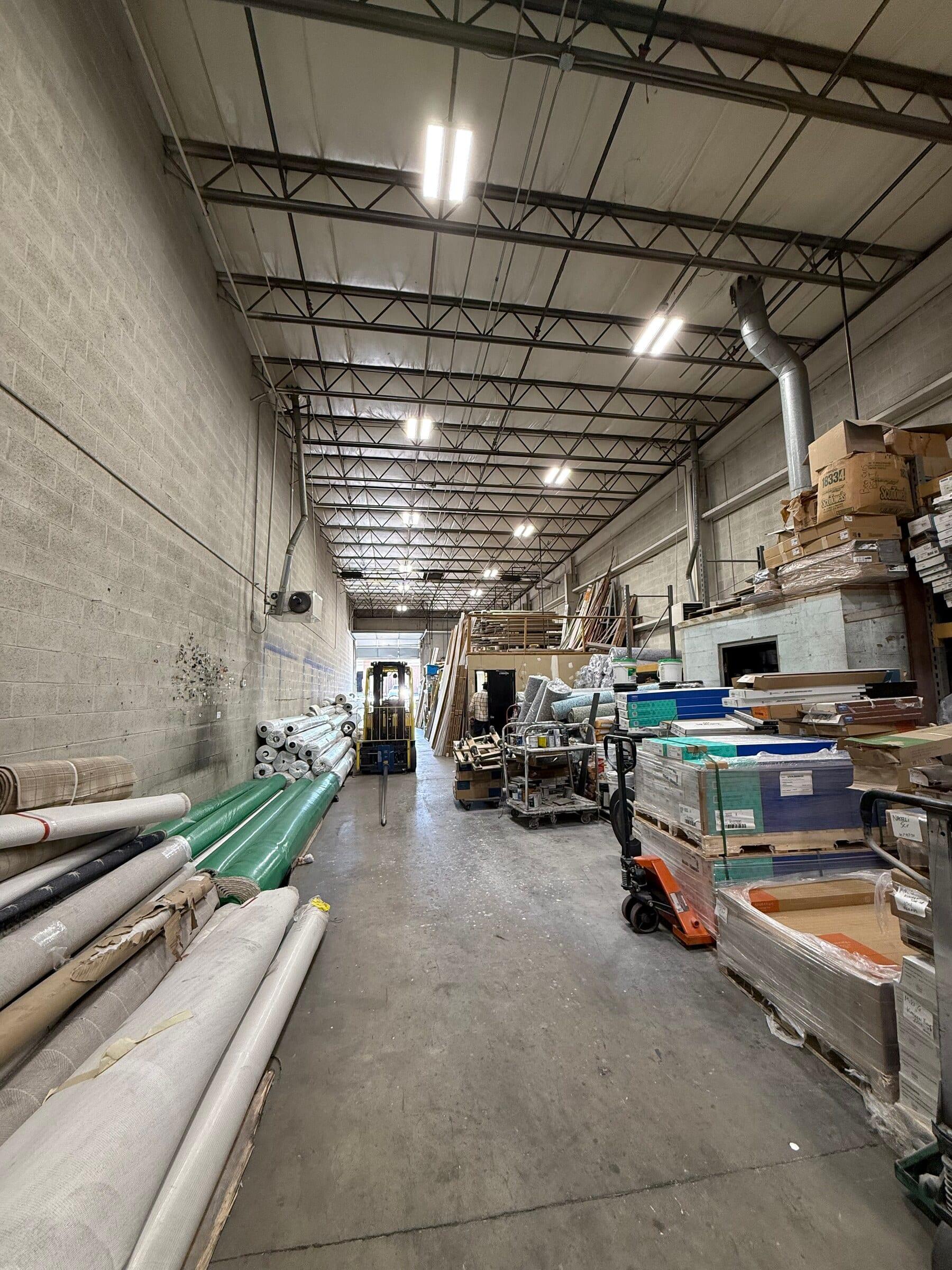 Rolls of carpet stacked on shelves inside the Gaithersburg warehouse.